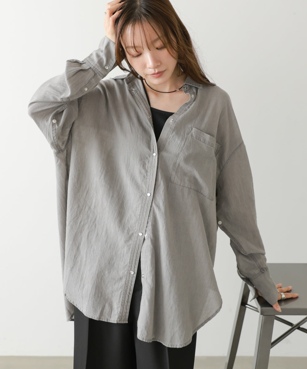 光沢感のある釦と、ゆとりのあるシルエットが抜け感のある大人カジュアルを演出